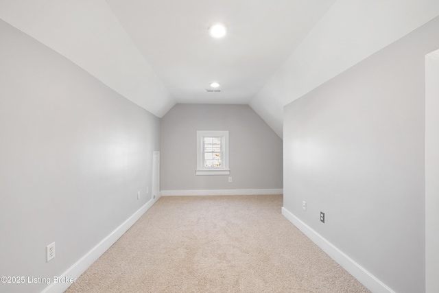 additional living space featuring lofted ceiling and carpet flooring