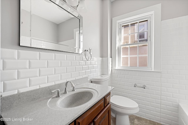 bathroom featuring vanity, tile walls, and toilet