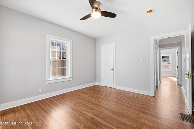 unfurnished bedroom featuring multiple windows, hardwood / wood-style floors, and ceiling fan