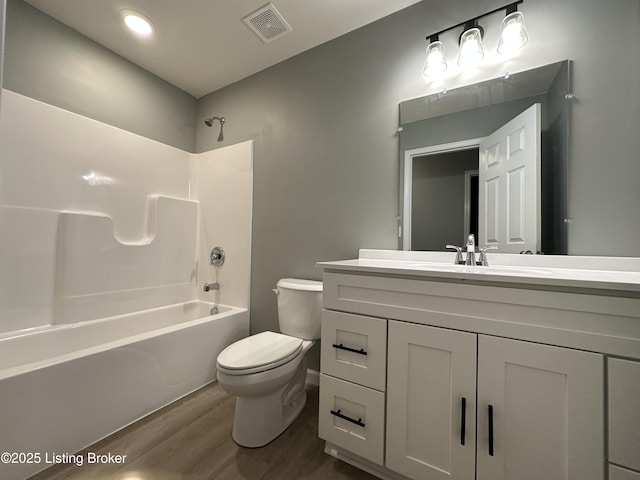 full bathroom with hardwood / wood-style flooring, shower / washtub combination, toilet, and vanity