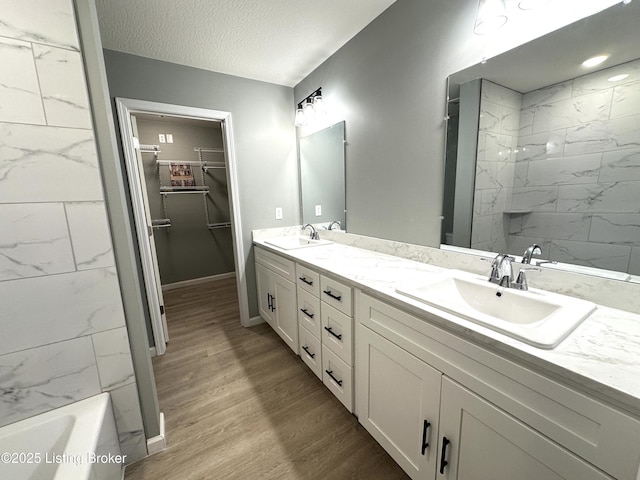 bathroom featuring wood-type flooring, vanity, and a textured ceiling