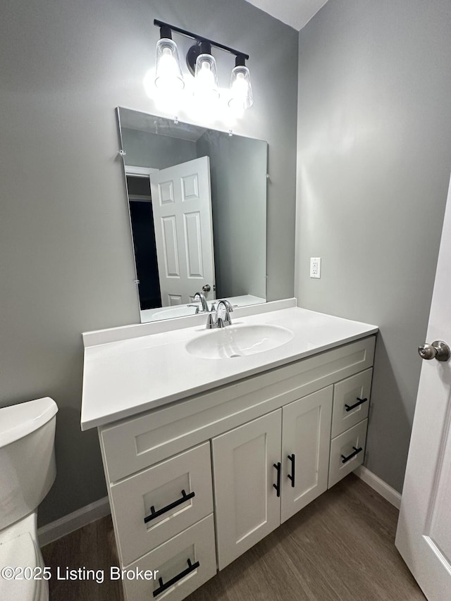 bathroom featuring hardwood / wood-style flooring, vanity, and toilet