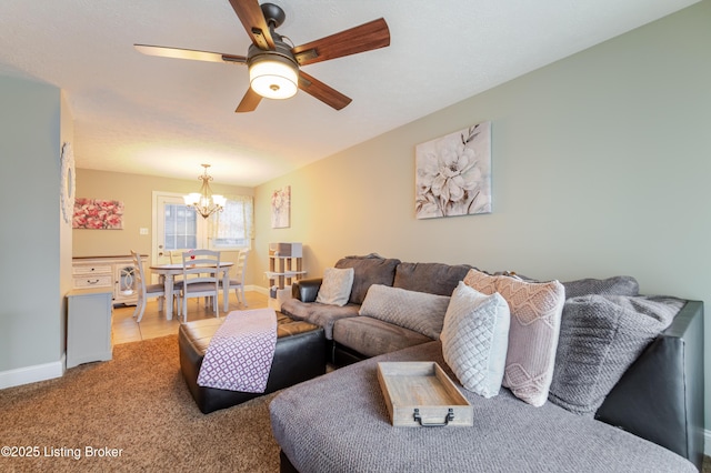 carpeted living room featuring ceiling fan with notable chandelier