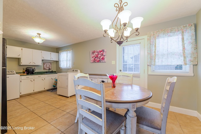 tiled dining room featuring washer / clothes dryer, sink, and a textured ceiling