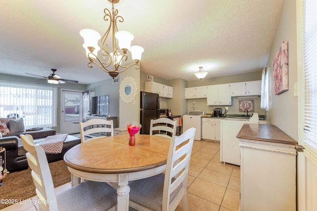 tiled dining room with washer / clothes dryer, ceiling fan with notable chandelier, and a textured ceiling