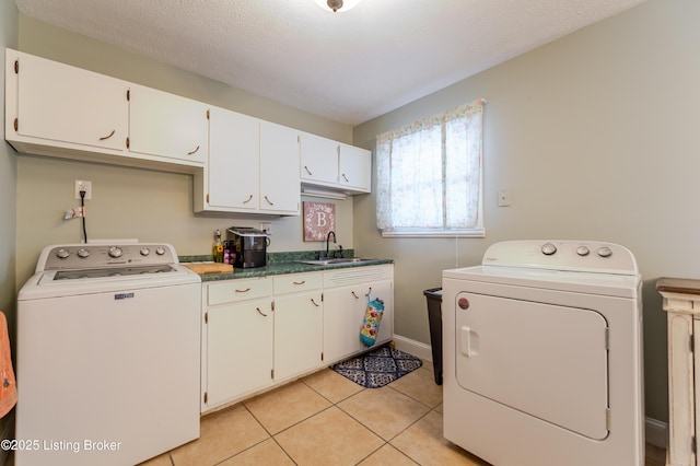 washroom with cabinets, washer and dryer, sink, and light tile patterned floors