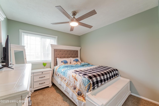 carpeted bedroom featuring ceiling fan and a textured ceiling