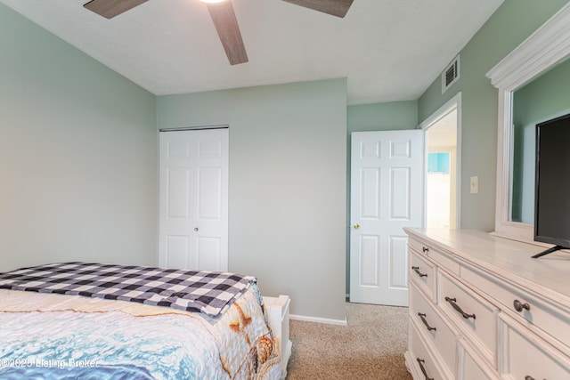 bedroom featuring light colored carpet, a closet, and ceiling fan