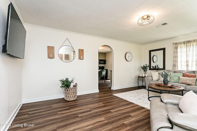 living room with dark hardwood / wood-style flooring and crown molding