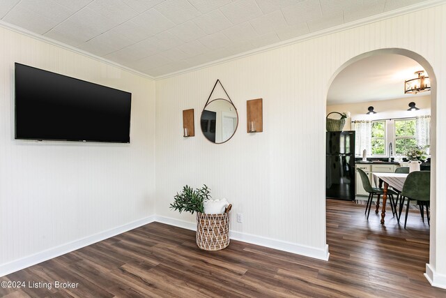 empty room with dark hardwood / wood-style flooring and ornamental molding