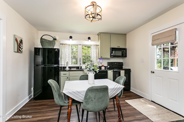 dining room featuring sink, dark hardwood / wood-style floors, a wealth of natural light, and a chandelier