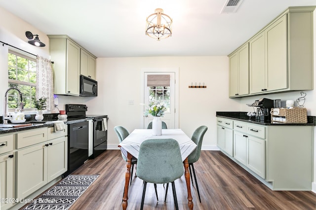 kitchen featuring sink, dark stone countertops, dark hardwood / wood-style flooring, and black appliances