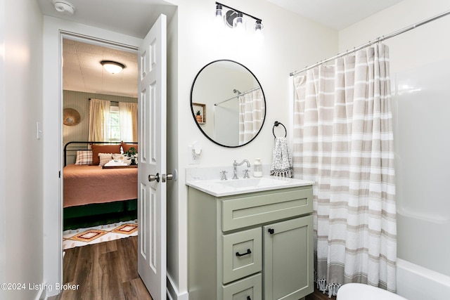 bathroom with wood-type flooring, shower / bathtub combination with curtain, and vanity