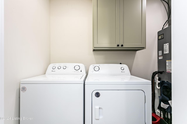 clothes washing area featuring washer and clothes dryer and cabinets