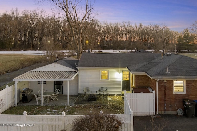 back house at dusk with a patio area