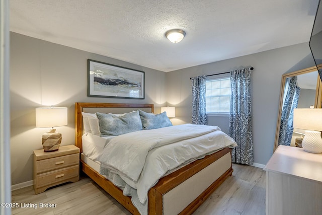 bedroom with light hardwood / wood-style flooring and a textured ceiling