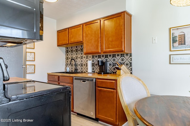 kitchen with backsplash, light hardwood / wood-style flooring, stainless steel dishwasher, and sink