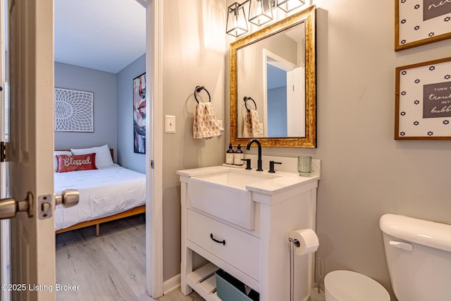 bathroom featuring vanity, hardwood / wood-style flooring, and toilet