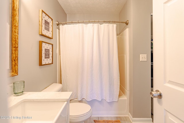 bathroom featuring shower / bath combo with shower curtain, a textured ceiling, and toilet