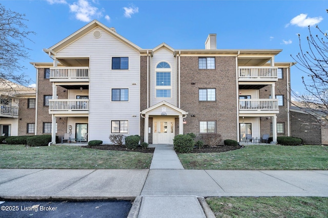 view of front of home featuring a balcony and a front yard