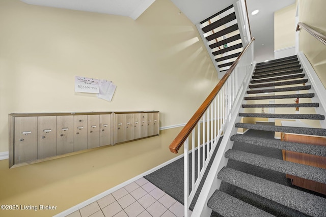 stairs featuring tile patterned flooring and a mail area