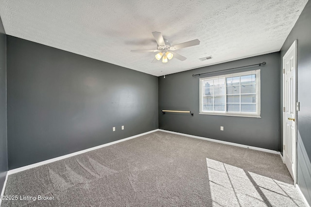 carpeted empty room featuring a textured ceiling and ceiling fan