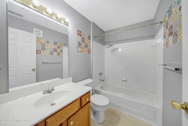 full bathroom featuring tiled shower / bath, vanity, toilet, and a textured ceiling