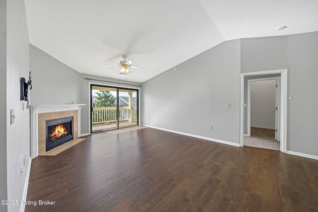 unfurnished living room with dark wood-type flooring, ceiling fan, a fireplace, and vaulted ceiling