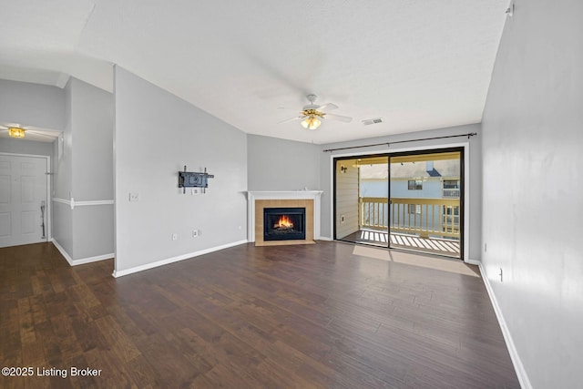 unfurnished living room featuring dark wood-type flooring, ceiling fan, lofted ceiling, and a fireplace