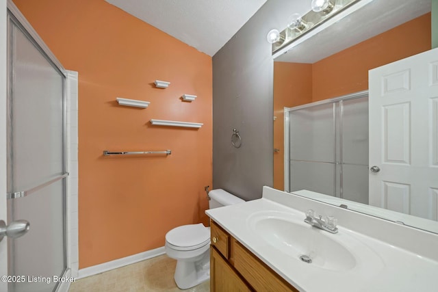 bathroom featuring vanity, toilet, and a shower with shower door