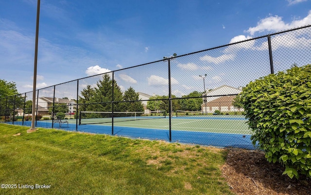 view of tennis court featuring a yard