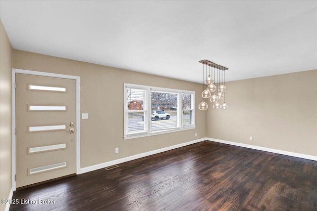 foyer featuring a chandelier and dark hardwood / wood-style flooring