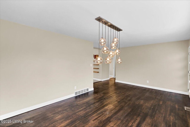 unfurnished dining area featuring a notable chandelier and dark hardwood / wood-style floors