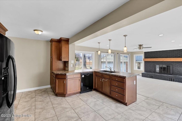 kitchen with sink, hanging light fixtures, kitchen peninsula, a fireplace, and black appliances