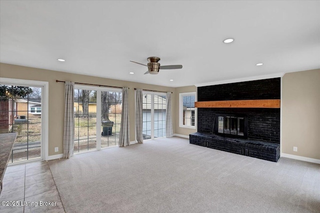 unfurnished living room featuring light carpet, a fireplace, and ceiling fan