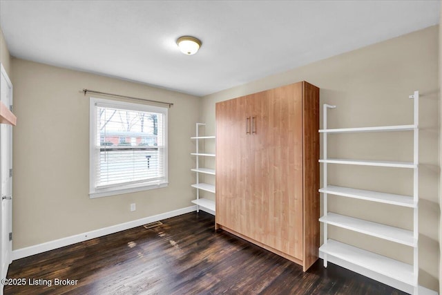 unfurnished bedroom featuring dark hardwood / wood-style floors and a closet