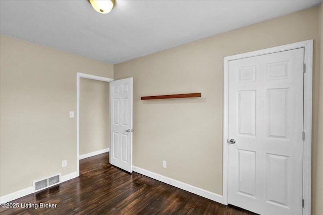 unfurnished bedroom featuring dark hardwood / wood-style flooring