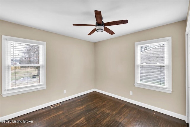 spare room with dark wood-type flooring and ceiling fan