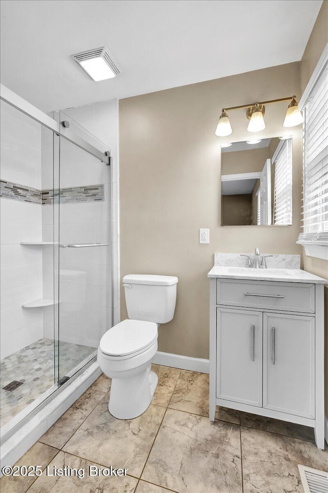 bathroom featuring vanity, toilet, and an enclosed shower