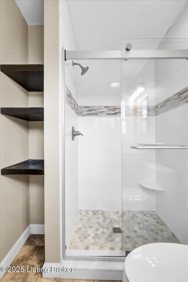 bathroom with a shower with door and toilet