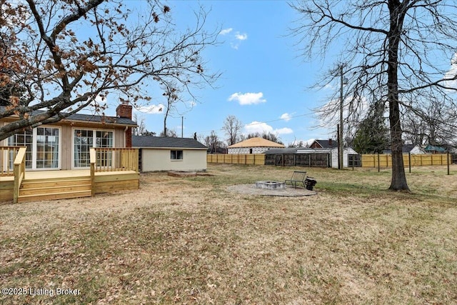 view of yard featuring a deck and a fire pit