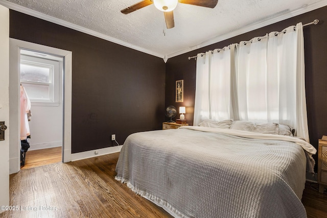 bedroom featuring wood-type flooring, crown molding, ceiling fan, and a textured ceiling