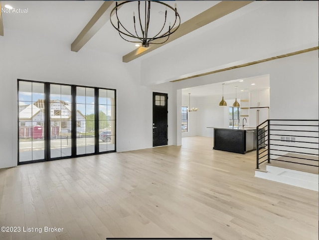 living room featuring an inviting chandelier, sink, beam ceiling, and light hardwood / wood-style floors