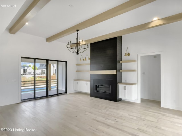 unfurnished living room with an inviting chandelier, beam ceiling, light hardwood / wood-style flooring, and a large fireplace