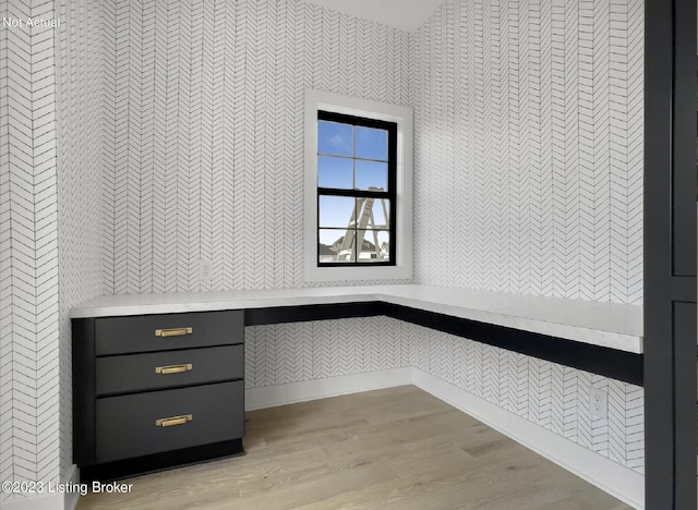 mudroom with built in desk and light hardwood / wood-style flooring