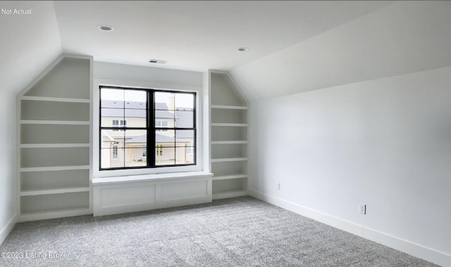 bonus room featuring lofted ceiling, carpet floors, and built in shelves