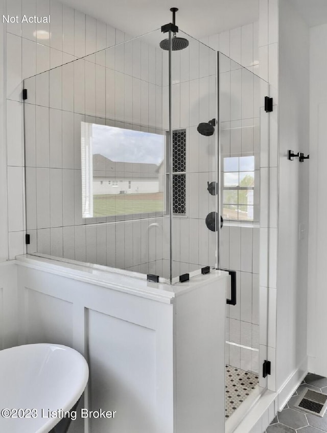 bathroom with shower with separate bathtub and tile walls