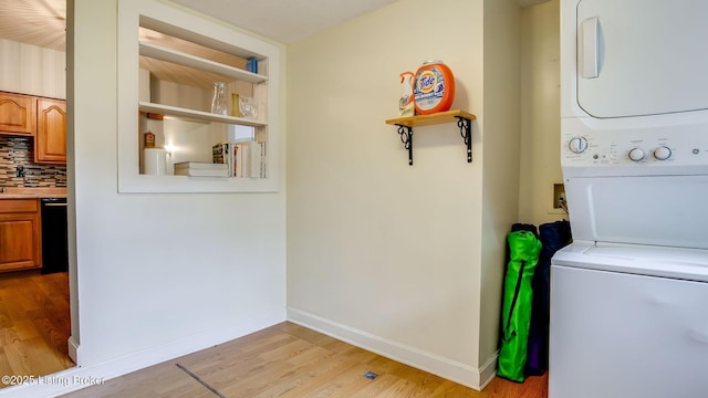 1014 E Oak St, Louisville, KY 40204 - washroom with stacked washer and clothes dryer, light wood finished floors, and baseboards