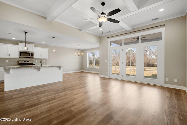 unfurnished living room featuring hardwood / wood-style flooring, coffered ceiling, ornamental molding, ceiling fan with notable chandelier, and beamed ceiling