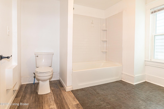 bathroom featuring bathing tub / shower combination, a healthy amount of sunlight, hardwood / wood-style floors, and toilet